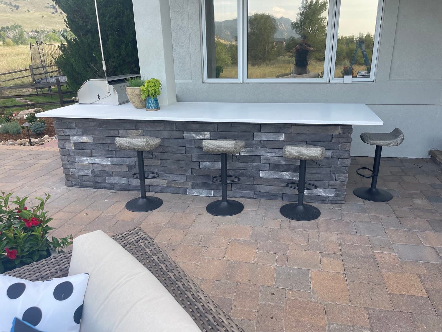 Outdoor kitchen bar with mountain views by J&P Landscaping