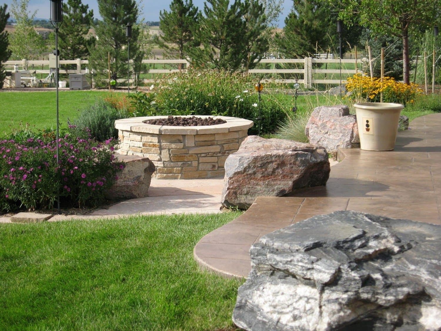 Stamped concrete patio with seat walls by J&P Landscaping